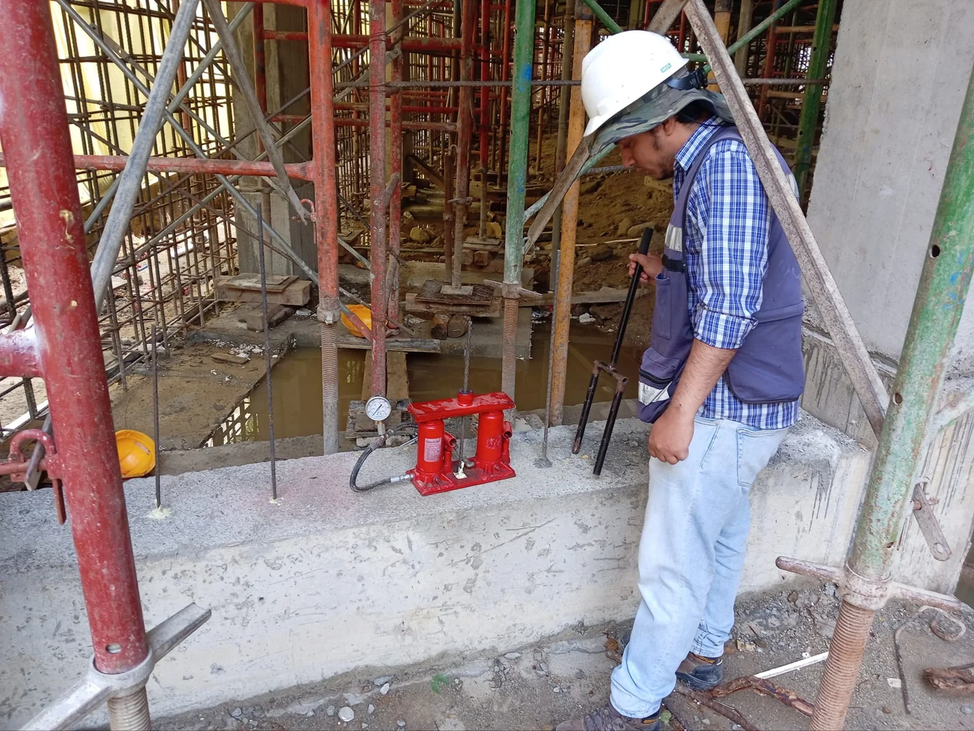 Técnico verificando un sistema de postensado en una estructura de concreto